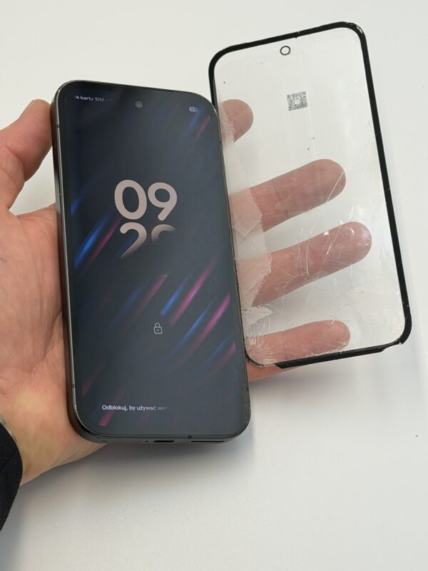 Google Pixel 9a z włączonym ekranem i oddzieloną pękniętą szybką